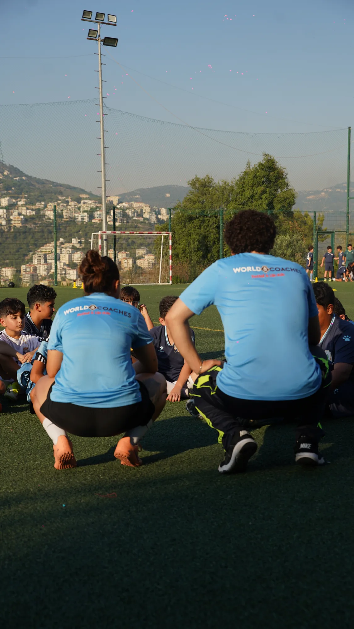 Coaches crouching to speak with the squad